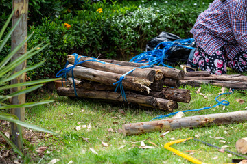 A carpenter is cutting and constructing a large tree crutches.