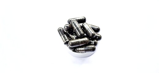 Herbal medicine black cumin capsules with negative space isolated on the gray white studio...