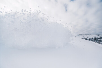 Splashes of snow from passing skier, snow explosion on  hillside