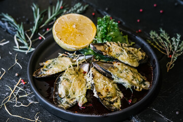 dish of baked mussels with lemon and herbs
