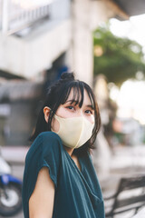 Young adult asian woman wear face mask for protect virus covid19 at outdoor on day