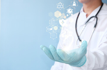 Doctor holding a virtual heart in his hand. shows a hand-drawn human organ with the color blue...