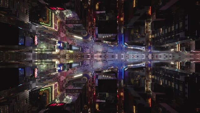 Top down shot of busy streets in city at night. Illuminated by commercial displays. Abstract computer effect digital composed footage.