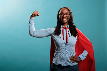 Arms muscle flexing brave superhero woman posing strong and tough for camera on blue background....