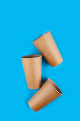 Disposable paper biodegradable cups on a blue background.