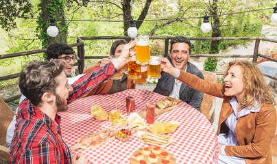 group of happy people toasting with beers and enjoying time together at the brewery during the weekend