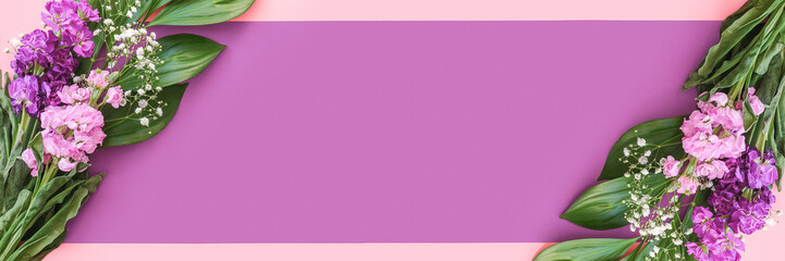 Banner made with bouquets of flowers on pink purple background. Flat Lay Copy space Top view...