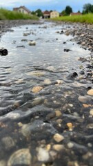 Der Regen hat einen kleinen Weg mit Wasser geflutet. Das Regenwetter sorgt für eine kleine Erfrischung im Sommer. Der Himmel im Hintergrund lässt weiteren Niederschlag erahnen.