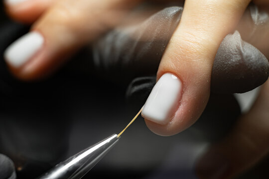 Manicure nail paint with thin brush, Beautician Salon, Nails artist polish, modelation gel. manual manicure procedure. hands of a manicurist in black gloves