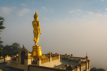 Fototapeta na wymiar Golden Buddha statue in the morning at Wat Phra That Khao Noi, or Phrathat Khao Noi temple, is the top attraction with a fantastic view of Nan province, Thailand