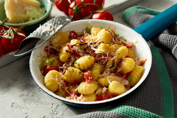 Tasty gnocchi dish served in pan on table