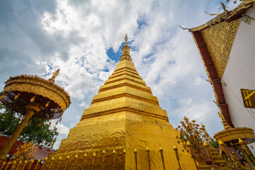 The gold pagoda in Wat Phrathat Cho Hae, Phrae province, Thailand. This gold pagoda is famous and was built on a mountain.