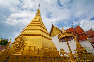 Fototapeta premium The gold pagoda in Wat Phrathat Cho Hae, Phrae province, Thailand. This gold pagoda is famous and was built on a mountain.