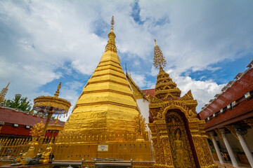 Fototapeta premium The gold pagoda in Wat Phrathat Cho Hae, Phrae province, Thailand. This gold pagoda is famous and was built on a mountain.