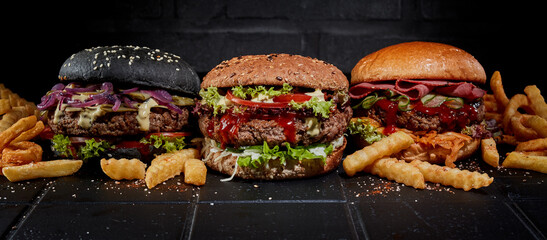 Fries and burgers on dark background in studio