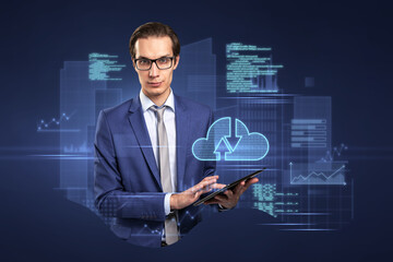 Attractive young european businessman with tablet standing on abstract blue background with coding...