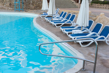 Hotel swimming pool, peaceful, relaxing and surrounded by nature. Clean swimming pool and sunbeds for tourists on holiday.