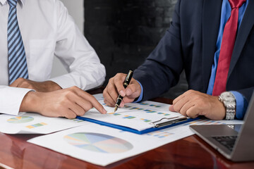 Two business leaders talk about charts, financial graphs showing results are analyzing and calculating planning strategies, business success building processes