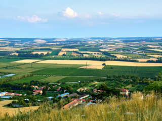 A view of the agricultural landscape of South Moravia around Mikulov. Fields and vineyard under blue summer sky. Suitable for tourist advertising.