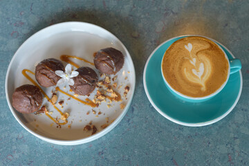 top view coffee latte in blue glass with banana cupcake on a white plate. selected focus. break time concept