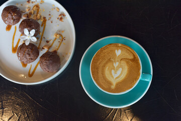 top view coffee latte in blue glass with banana cupcake on a white plate. selected focus. break time concept