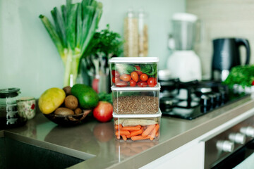 Fresh various vegetables and buckwheat in a container are on the table in the kitchen, the food is ready to eat.