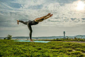 a woman ist practicing yoga at the beach