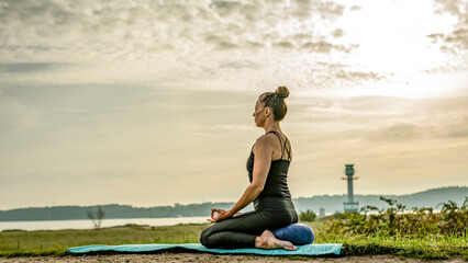 Fototapeta premium a woman ist practicing yoga at the beach