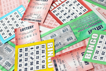 Many used lottery tickets, bills with numbers and bingo playing boards in big pile. Gambling and...