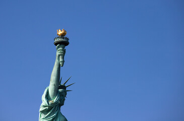 Vue sur la statue de la liberté à New York avec en arrière plan un beau ciel bleu de la la place...