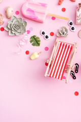 Accessories for beach summer party - longer chairs, umbrellas, ice cream top view. Beach party concept with copy space. Vertical format