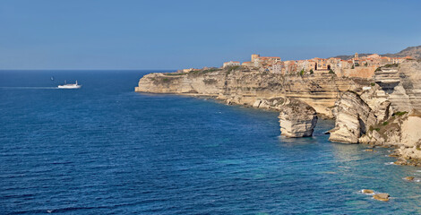 Bonifacio coastline with limestone cliff in the sea under clear blue sky in Corsica- France