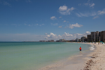 belle plage de sable en Floride avec mer turquoise et buildings en arrière plan. Marco Island, Naples.