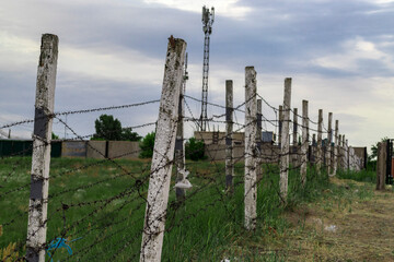 fence made of concrete poles and barbed wire