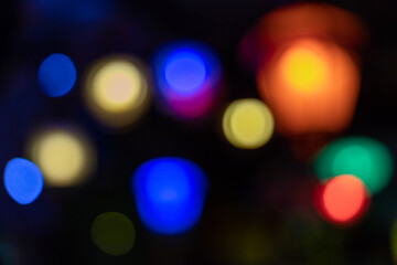 Abstract colorful bokeh lights at night with blurred defocused glow. Festive holiday background with copy space, ideal for Christmas and celebration design.