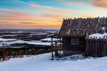 Santa's cottage in the hills of Levi ski resort in the Finnish Lapland at sunset.