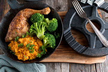 Fitness meal with roasted chicken leg, pumpkin puree and broccoli