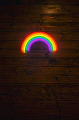 led neon rainbow hanging on the wooden wall