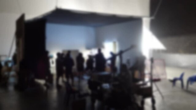 Blurry footage to represent overview working for video production in studio. Behind the scenes of video production. Shooting or filming a movie by director and film crew team with camera lighting set.
