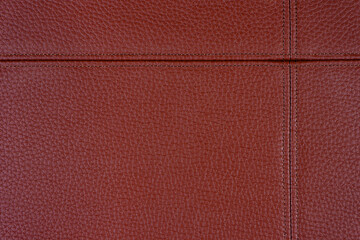 Fototapeta premium Natural, artificial red leather texture background with decorative seam. Material for sport items, clothes, furnitre and interior design. ecological friendly leatherette.