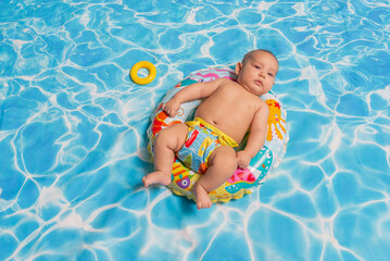 Studio portrait of a baby enjoying in a swimming pool.