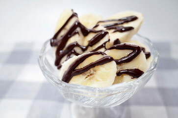 チェックのマットに可愛いカップに入ったチョコバナナ