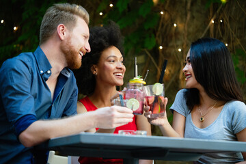 Multiracial group of friends having fun and talking in restaurant