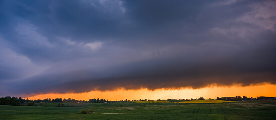 Storm cloud in the sunset light, shelf cloud with dramatic light