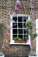Union Jack flags on the street during queens jubilee celebration. Street party decorations in the UK city. Selective focus - obrazy, fototapety, plakaty