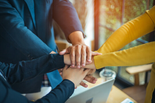 A group of young people hands coordination is a symbol of unity within the organization to strive for the success of the team and the company. The concept of unity within a business.