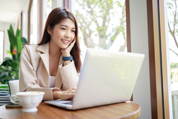 Asian businesswoman use computer laptop in the coffee shop