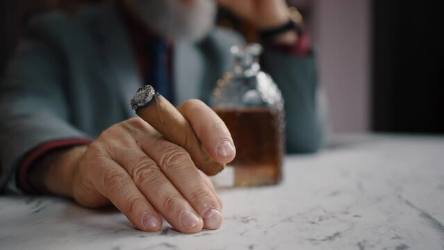 Unrecognizable successful businessman resting with cuban cigar and aged whiskey, enjoying harmful habits, free space