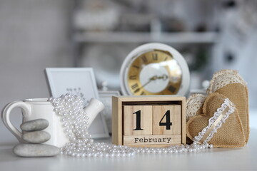 Valentines day concept. heart beside wooden block calendar set on Valentines date 14 February on table and bright room background.