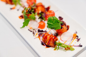 a plate with beautifully served trout rolls. fish delicacies 